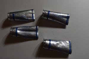 four silver shells with blue writing and stripes