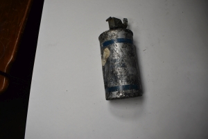 old silver spent grenade can with blue writing and lines but its all banged up and coated with gunk so hard to read