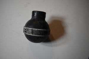 a hand ball rubber black grenade, about softball sized, with white writing that says CTS and then a lot of tiny writing