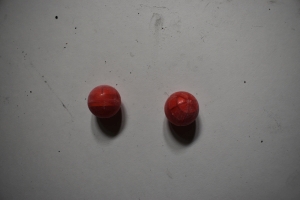 two red powder balls with the globe clearish red plastic indicative of a RAP4 round