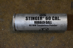 The Stinger 60Cal Rubber Ball canister reads; 40mm smokeless powder. The canister is a dull grey of slightly textured metal. Slight scratches in the metal almost indistinguishable to the touch. The back says it's made by Defence Technology. To be used by trained law enforcement, correctional or military personnel. Not to be used for operations after 5 years from the date of manufacture. Below this it says `Safariland`